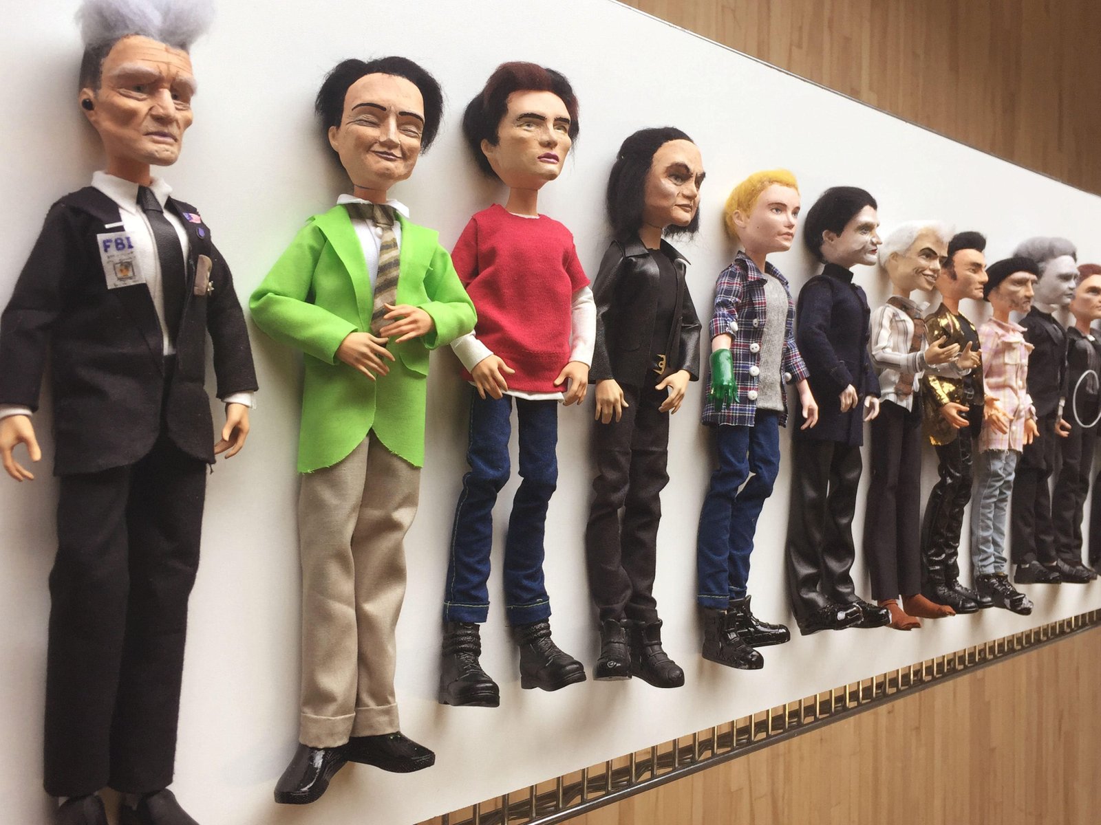 Men of Lynch dolls lined up against a wall