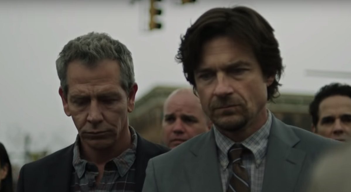 Terry and Ralph both looking down as they walk towards the courthouse