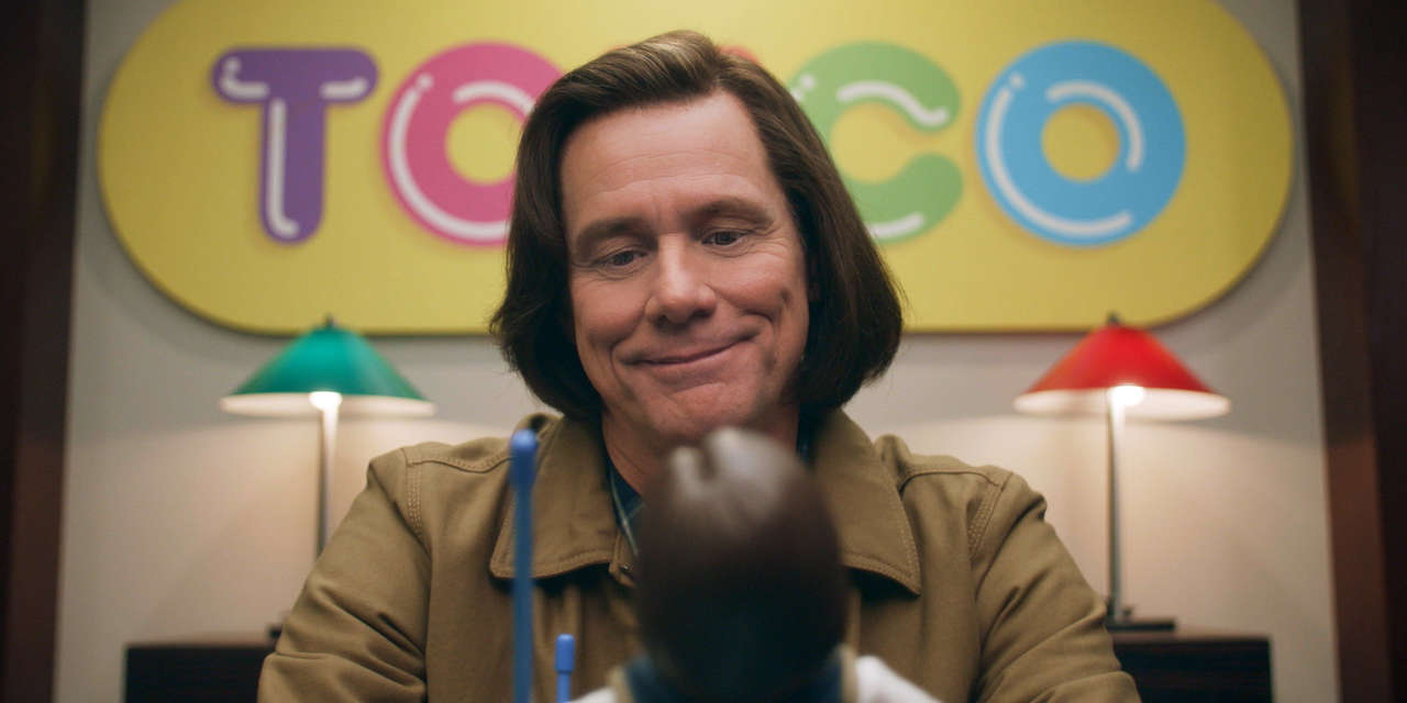 Jeff smiles while looking at the new Jeff doll that can listen and speak to children