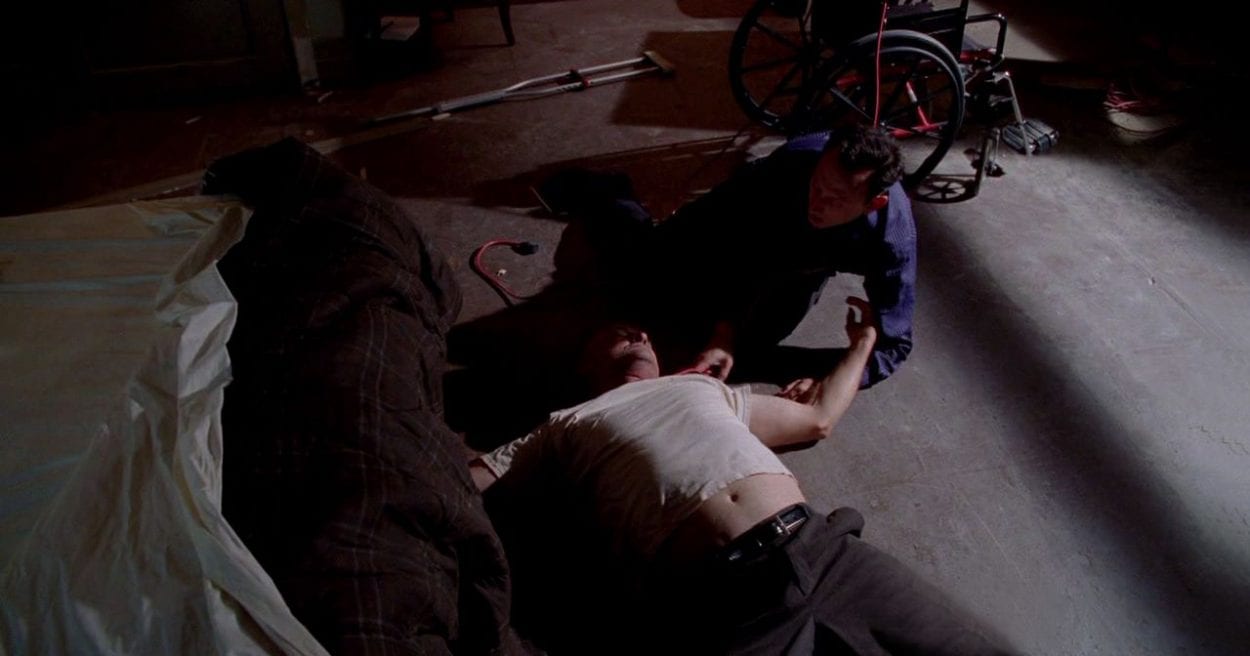 Ben sits next to Locke after strangling him to death