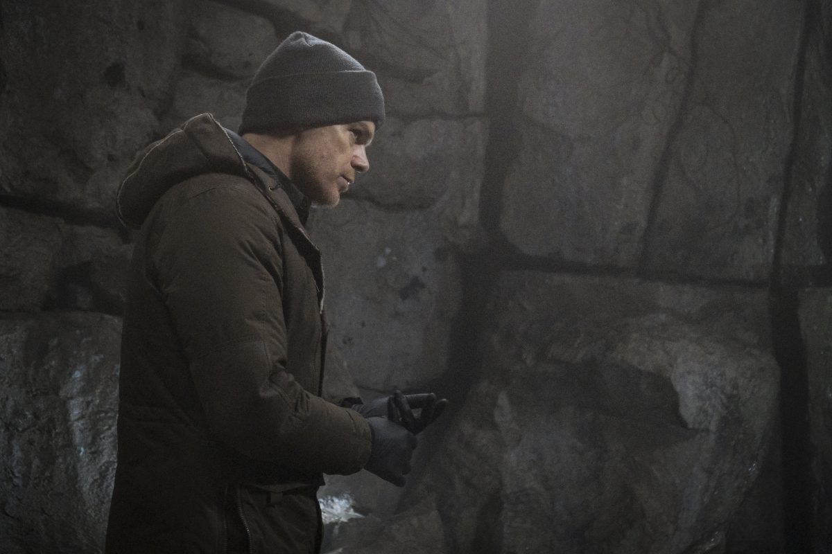 Dexter wears a beanie as he looks around a cave