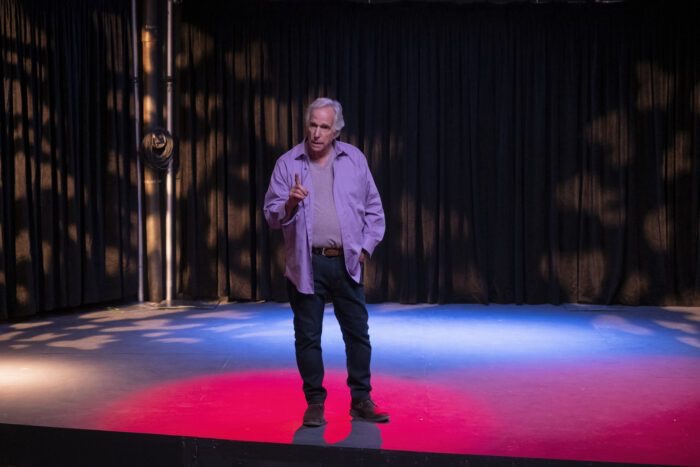Gene onstage giving a speech in the Barry S4 premiere.